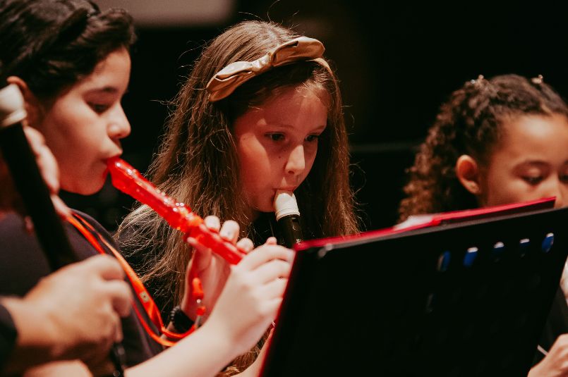Crianças tocando flauta doce em um Concerto.